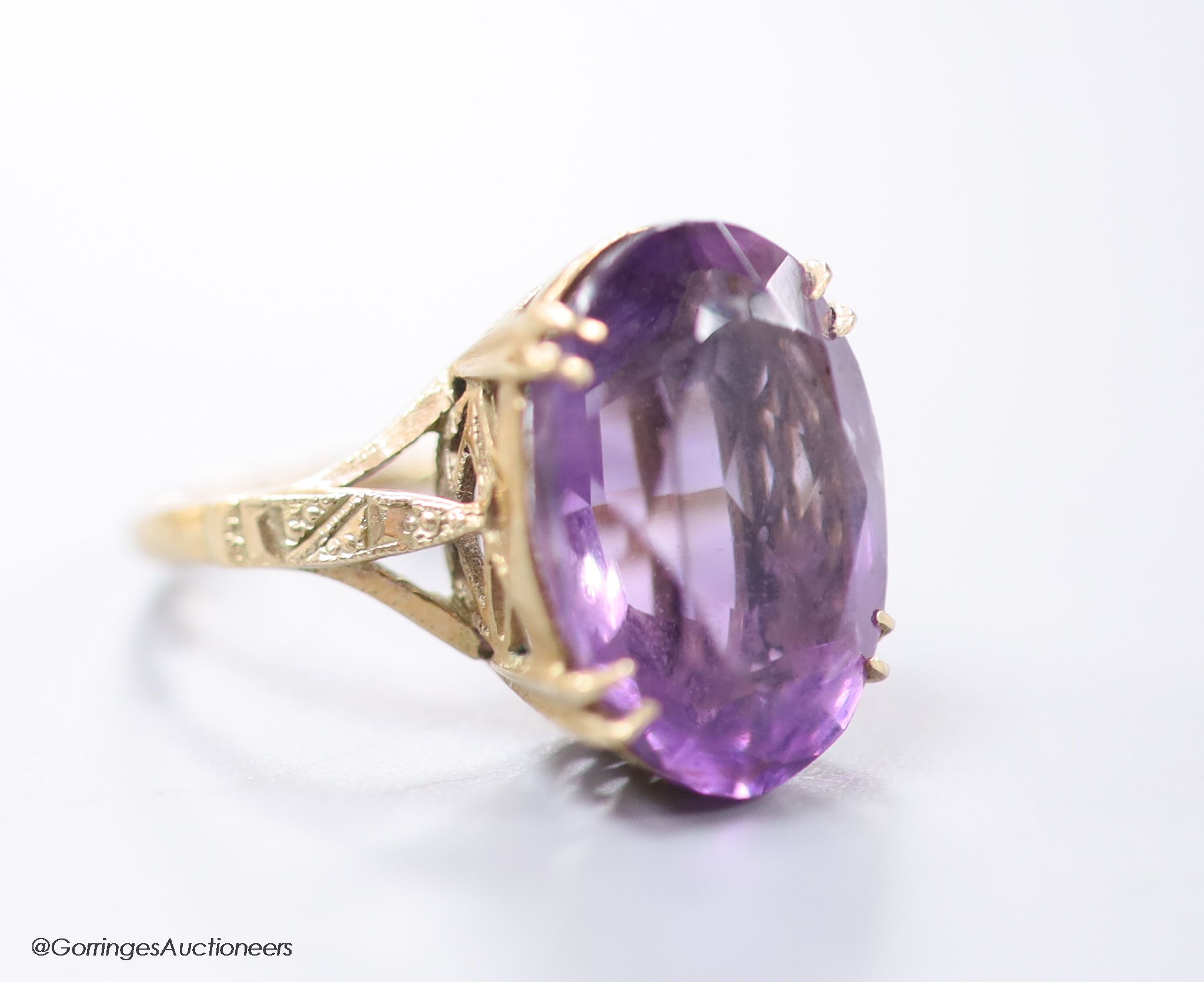 A 9ct gold and oval cut amethyst set dress ring, size H